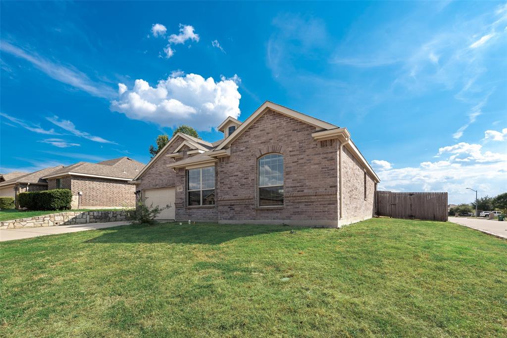 Brick exterior with an attached garage, arched window, and gabled roofline Brick exterior with an attached garage, arched window, and gabled roofline
