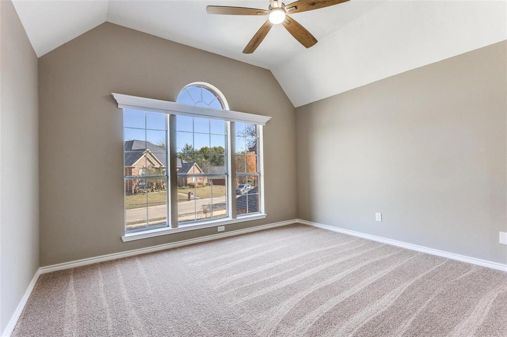 Bedroom upstairs has vaulted ceiling, ceiling fan, arched window with transom, and NEW neutral carpeting
