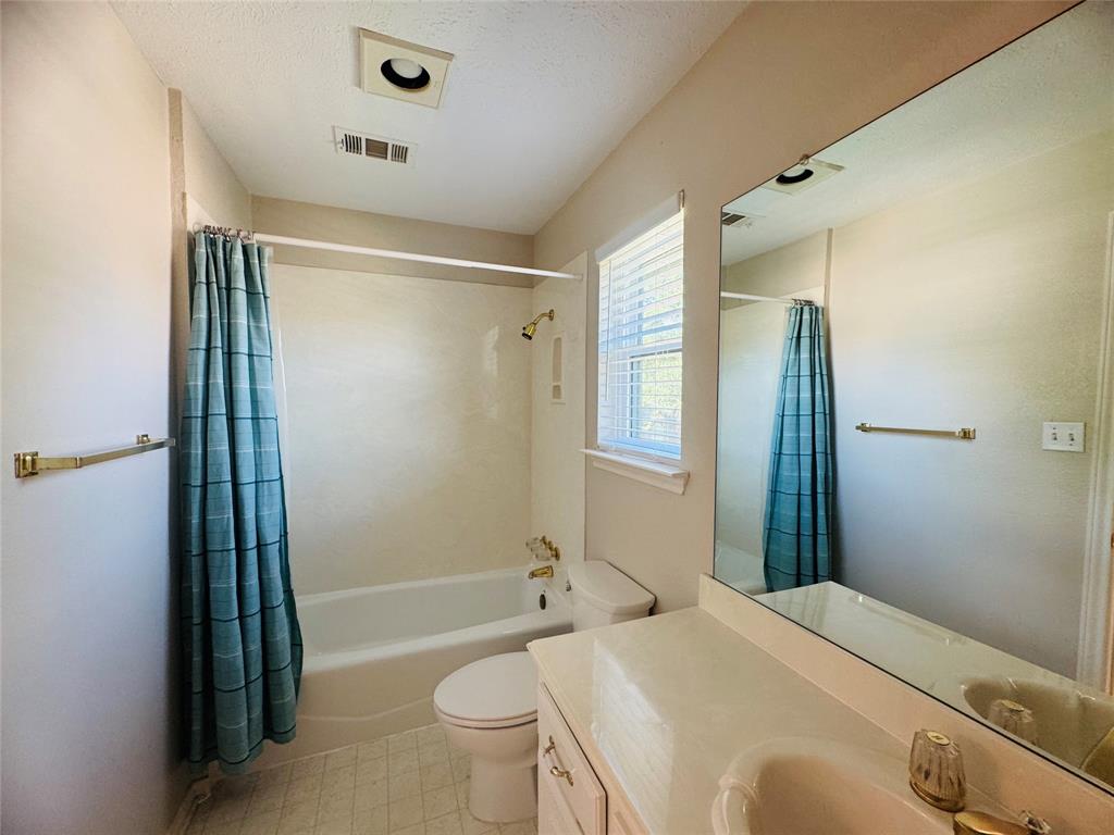 Bathroom featuring a full-length vanity mirror, white bathtub, vanity with integrated sink, and privacy window with blinds