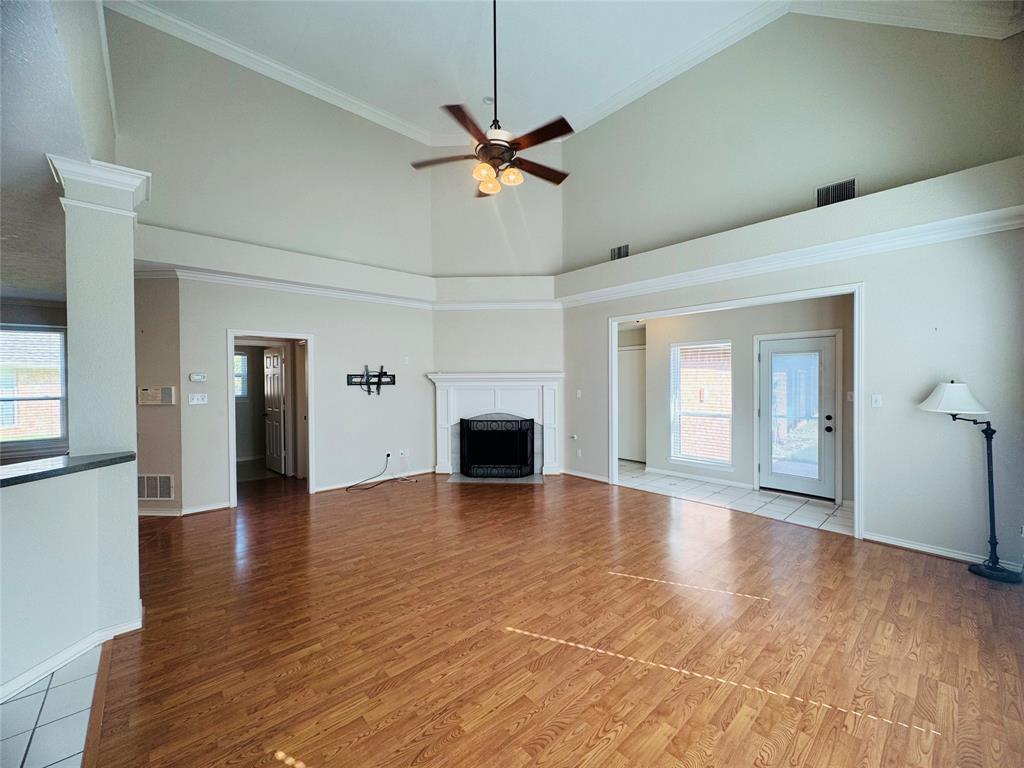 Vaulted ceilings, wood-finish flooring, white mantel, and a ceiling fan with integrated lighting Vaulted ceilings, wood-finish flooring, white mantel, and a ceiling fan with integrated lighting