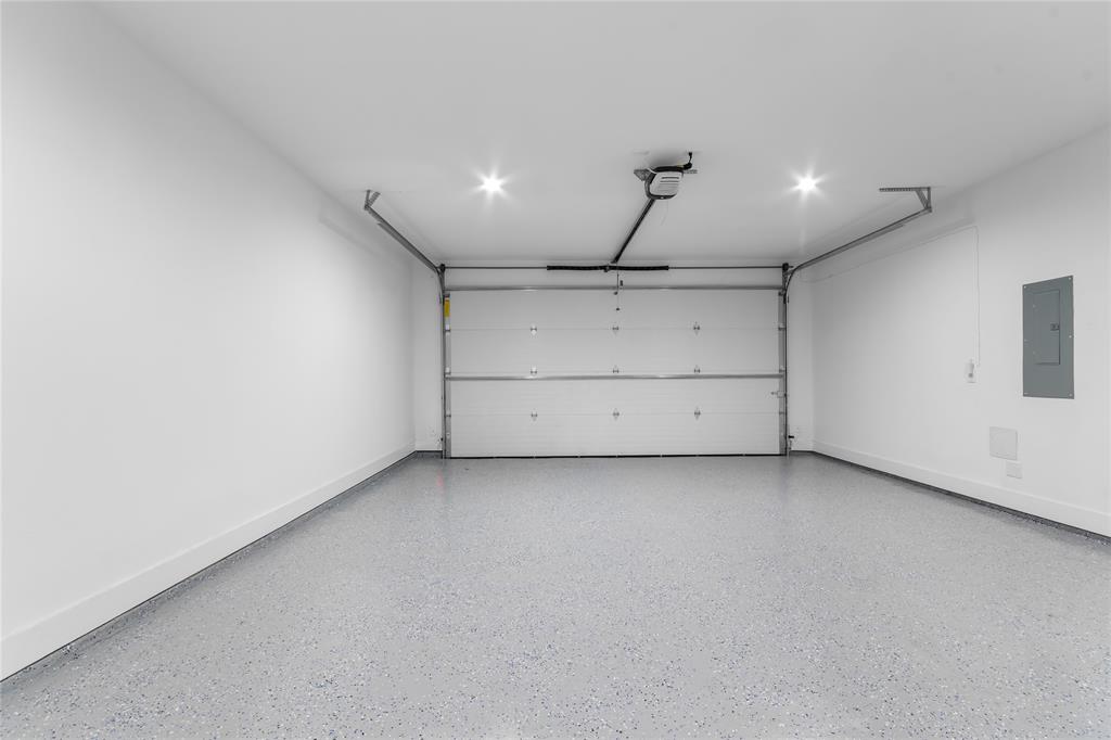 Garage featuring an automatic overhead door, recessed lighting, and a durable speckled epoxy floor finish
