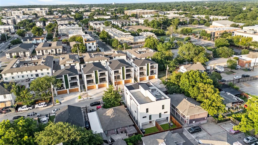 Aerial view of a residential area featuring modern multi-story townhomes with flat roofs and balconies