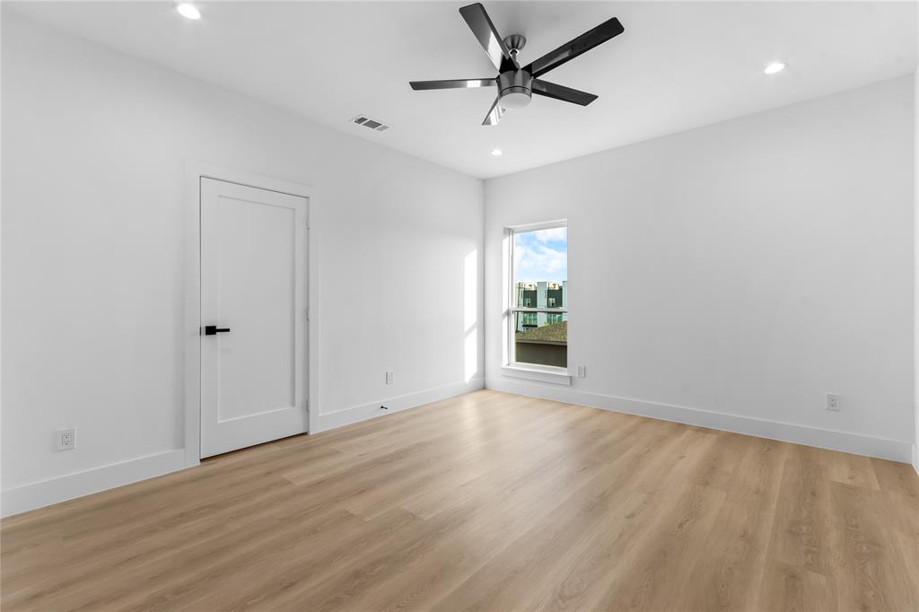 Spacious room featuring wood-finish flooring, recessed lighting, and a contemporary ceiling fan