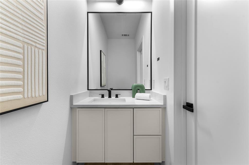 Modern bathroom vanity featuring a light-toned cabinet, integrated sink, and stone-finish countertop