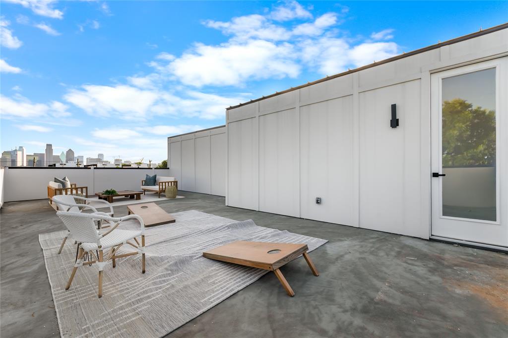 Rooftop deck featuring a city skyline, concrete flooring, and modern white paneling