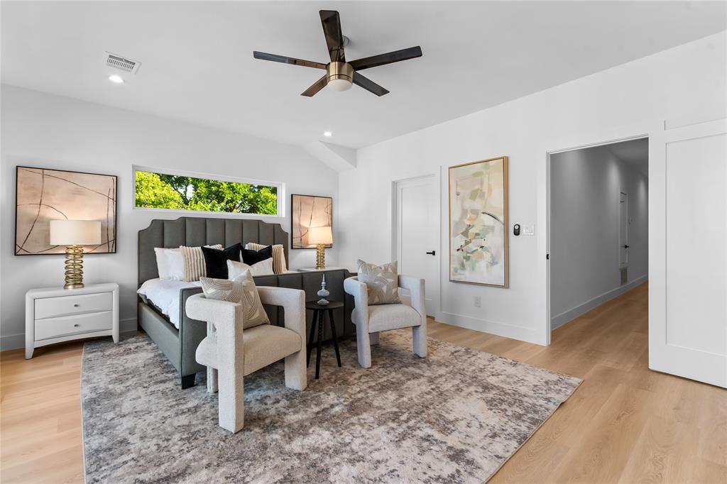 Bright bedroom with vaulted ceilings, recessed lighting, a modern ceiling fan, and light wood-finish flooring