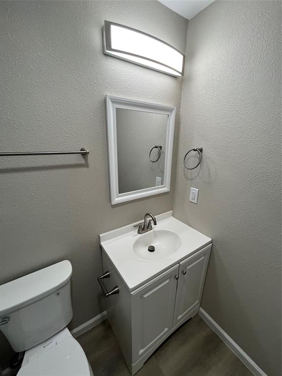 White vanity with a single basin sink and brushed nickel faucet