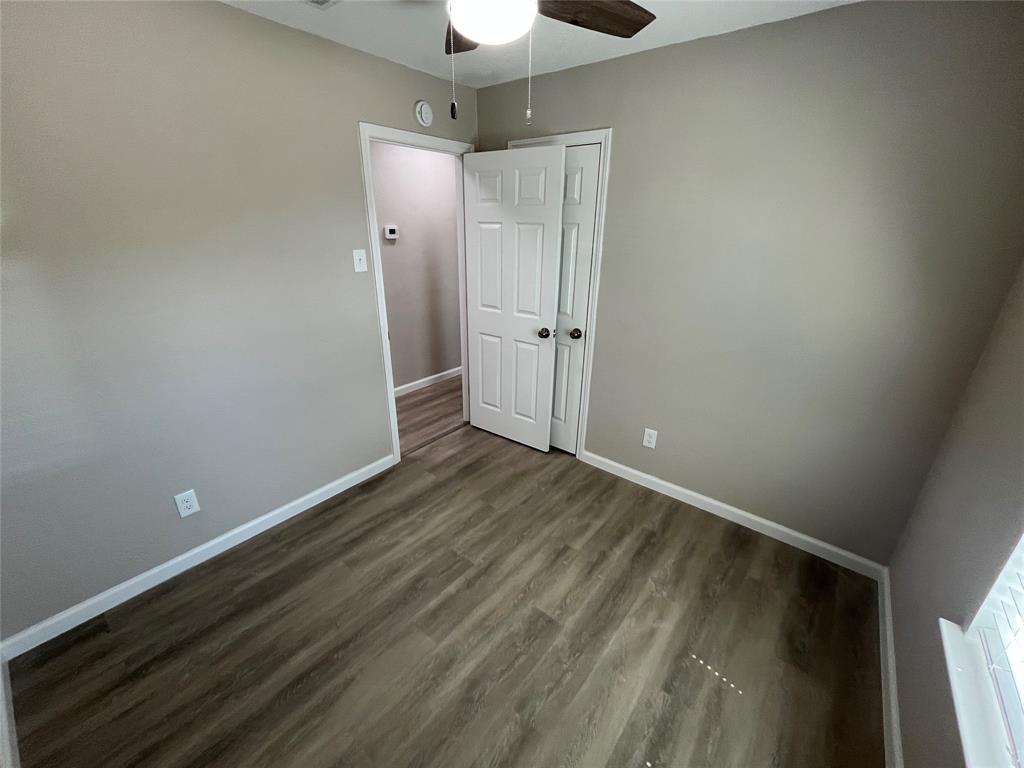 Wood-finish flooring throughout, neutral wall color, and white trim