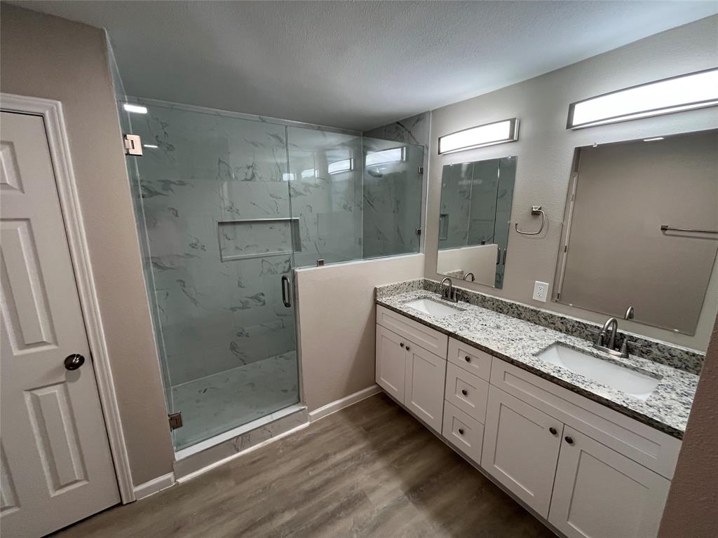 Expansive dual vanity with stone countertops, under-mount sinks, and individual mirrors