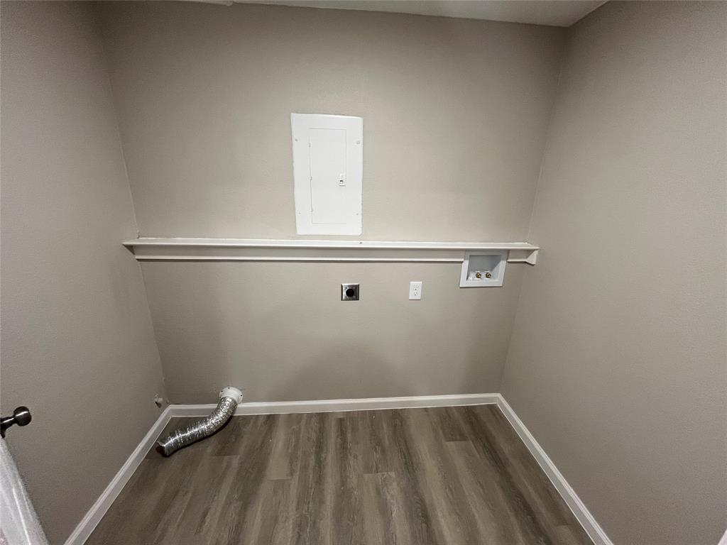 Wood-finish flooring, white wall trim, and a utility shelf