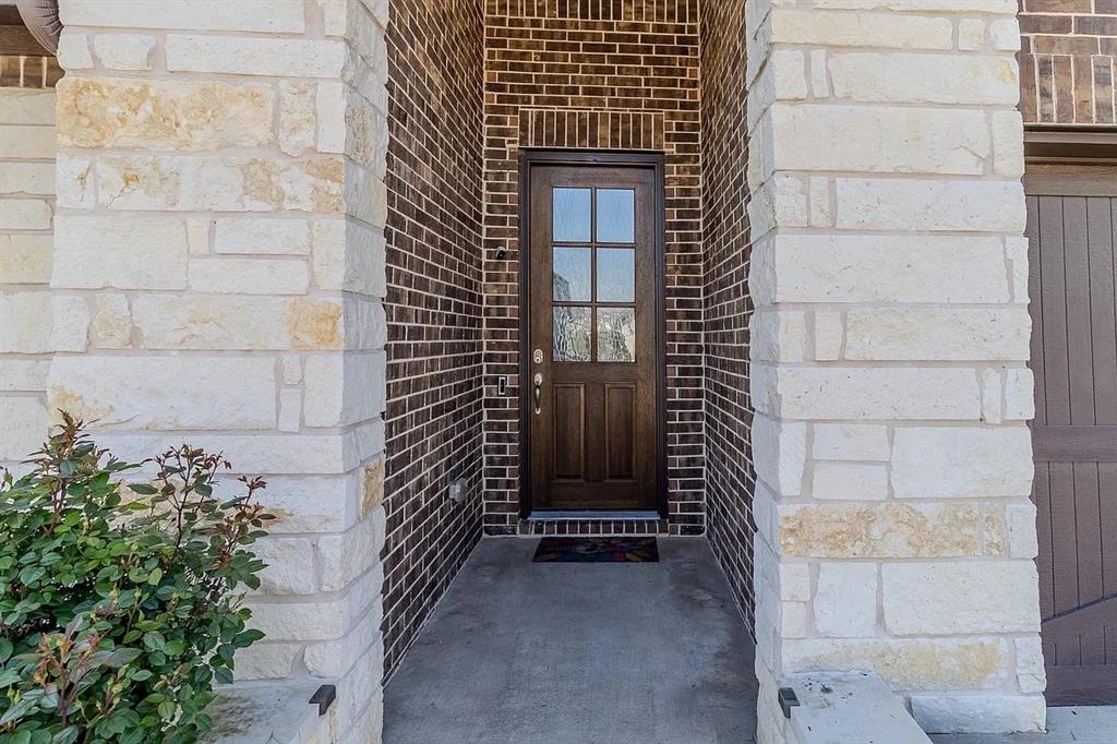 Stone and brick exterior with a wood-finish front door and multi-pane glass inserts