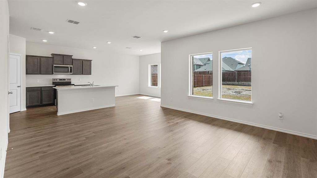 Open-concept living space featuring wood-finish flooring, recessed lighting, and white walls
