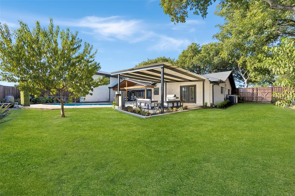 Expansive backyard wiht sparkling pool, two covered outdoor patios, mature trees and plenty of green space for outdoor enjoyment.