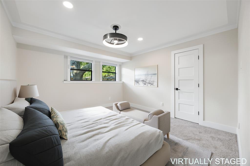 Guest bedroom featuring neutral finishes, abundant natural light, a modern ceiling fan, fresh carpet and generous closet space.