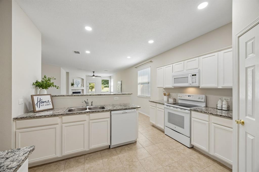 Cooking Without Missing What’s Happening – The open kitchen keeps the family room and casual dining area within view, making it easy to prepare meals while staying connected to conversation, guests, or the golf course views beyond.