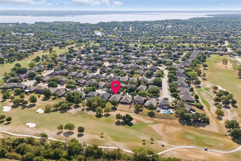 Golf Course Living with Lake Ray Hubbard on the Horizon – This elevated view captures the home’s enviable position along Waterview Golf Course, with the fairway stretching behind the property and Lake Ray Hubbard creating a scenic backdrop in the distance.