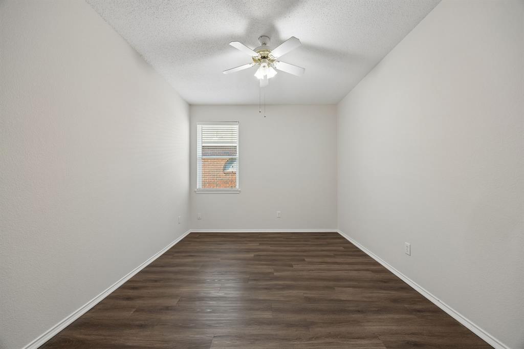 A Secondary Bedroom with Real Space – This generously sized secondary bedroom offers LVP flooring, a ceiling fan, and enough wall space for a comfortable furniture arrangement without feeling crowded.