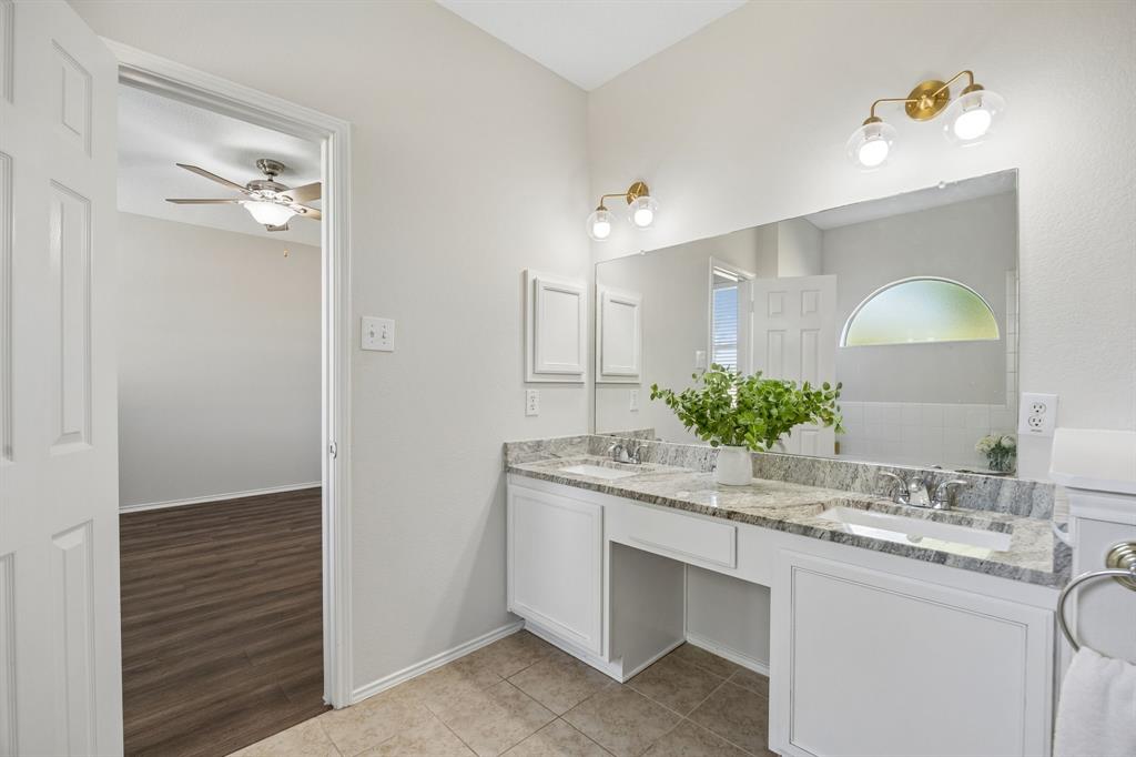 Double Vanities Make Mornings Easier – The ensuite bath features a long dual-sink vanity with a granite top, updated fixtures, and generous counter space, complemented by a jetted tub and separate walk-in shower for a well-planned primary bath.