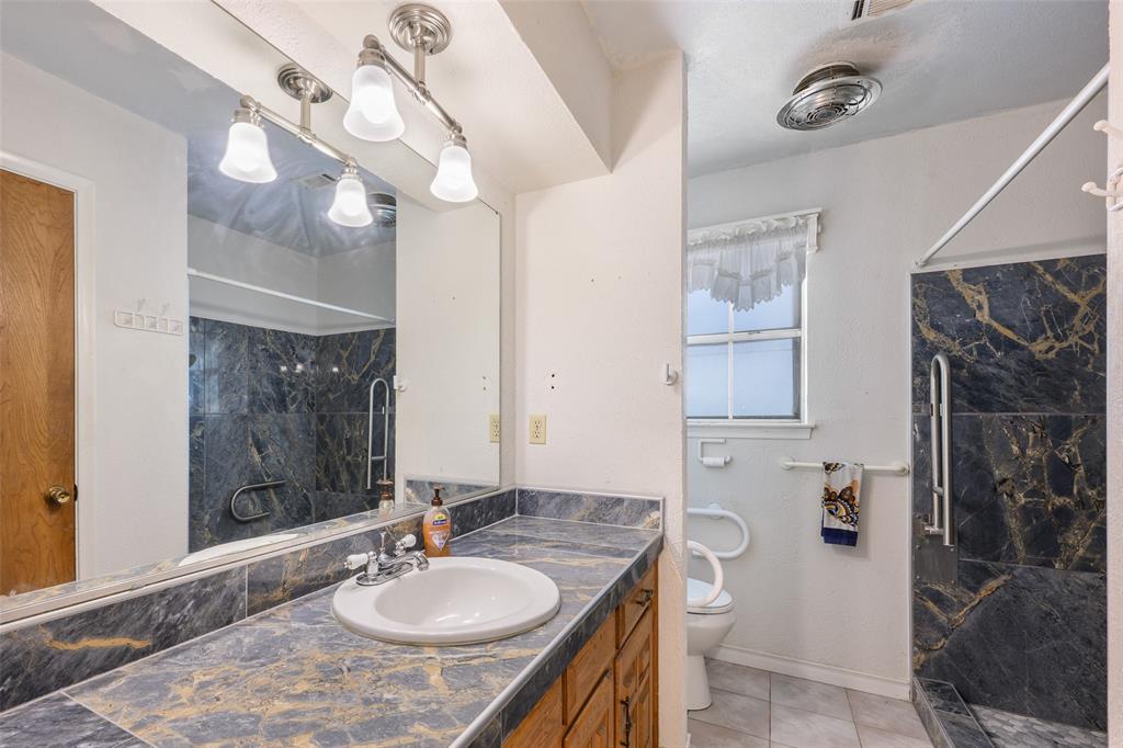 Vanity with integrated sink, patterned countertop, and mirrored wall
