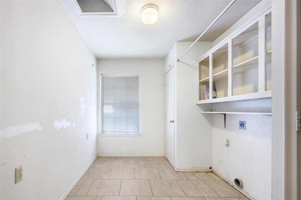 Ceramic tile flooring, built-in upper cabinetry, and a ceiling-mounted light fixture