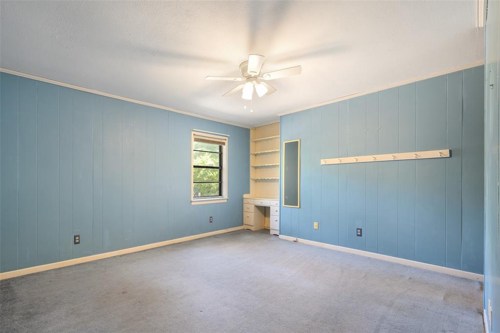 Built-in shelving, integrated desk, and ceiling fan with lighting