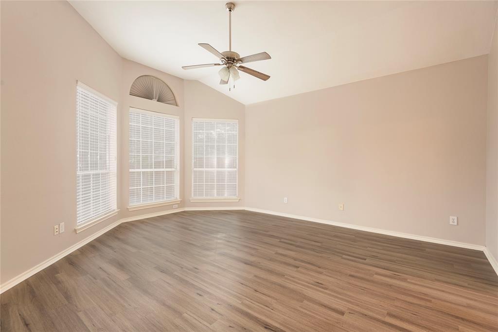Spare room featuring ceiling fan, dark wood-type flooring, and vaulted ceiling