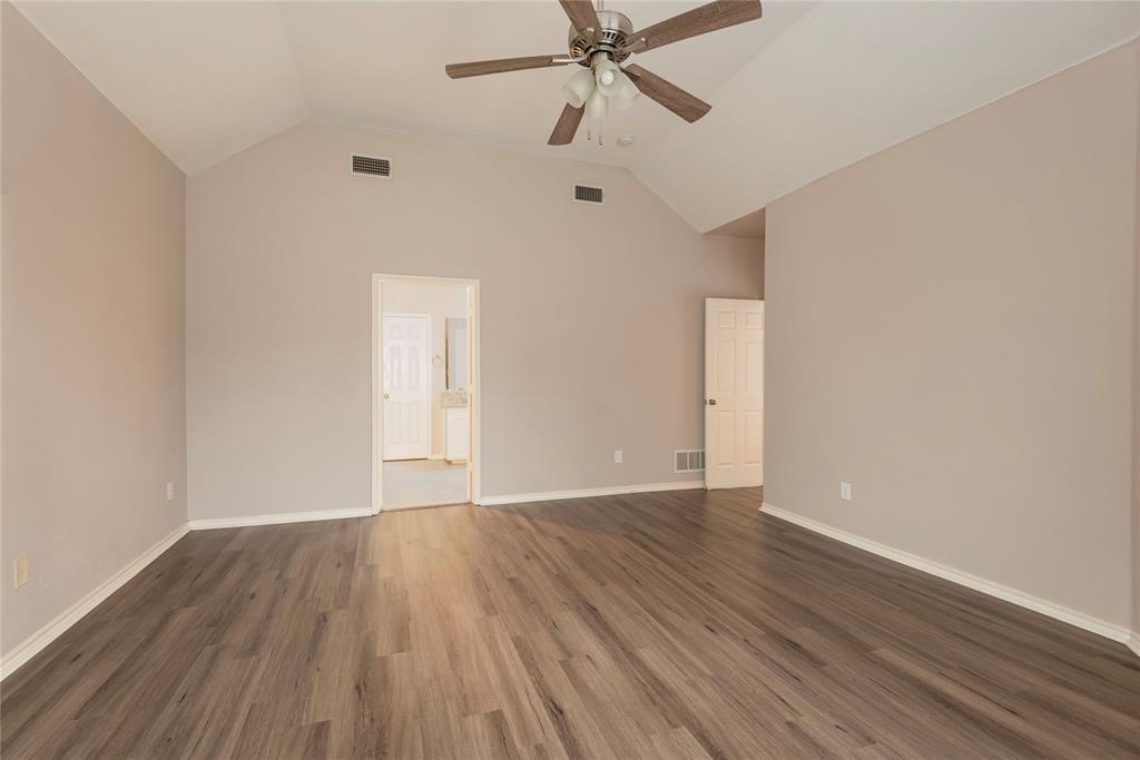 Empty room featuring ceiling fan, dark hardwood / wood-style flooring, and vaulted ceiling