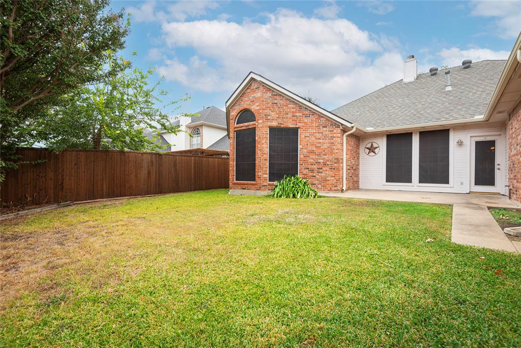 Rear view of house with a lawn and a patio