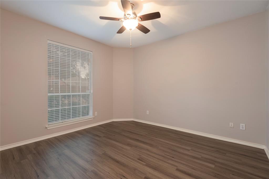Unfurnished room featuring ceiling fan and dark wood-type flooring