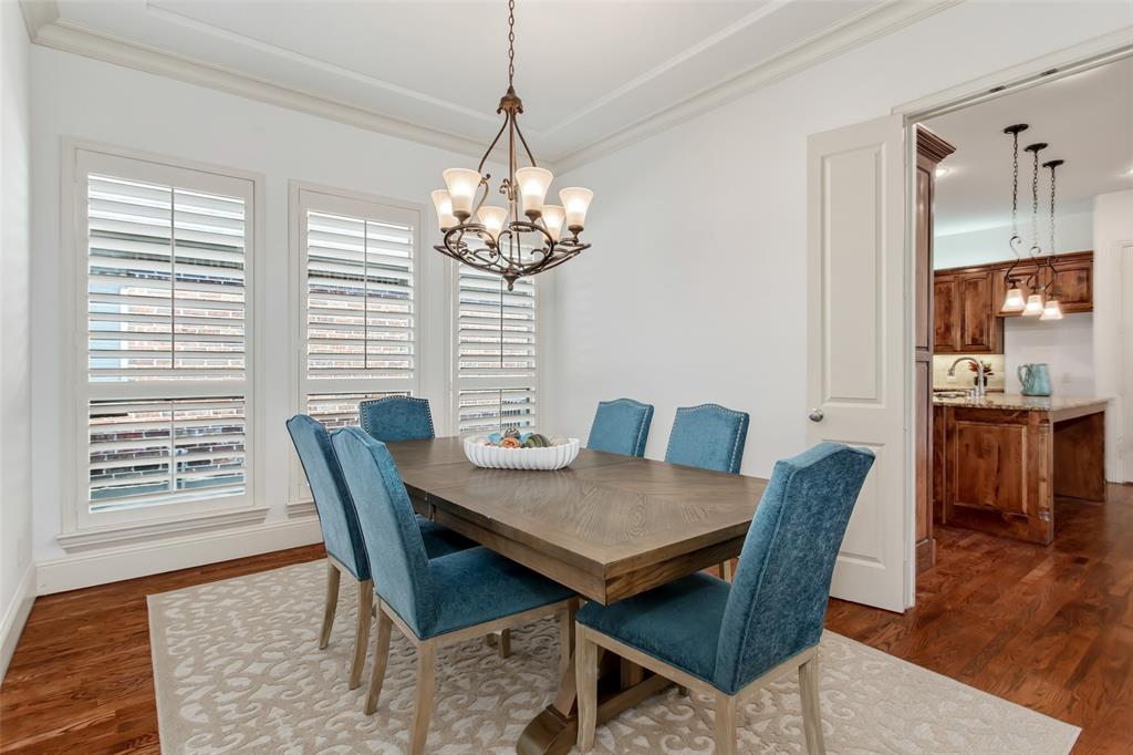 Dining area with hardwood flooring, crown molding, and plantation shutters