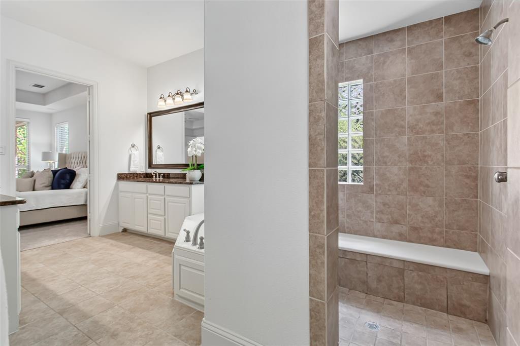 Tiled walk-in shower with a built-in bench and glass block window
