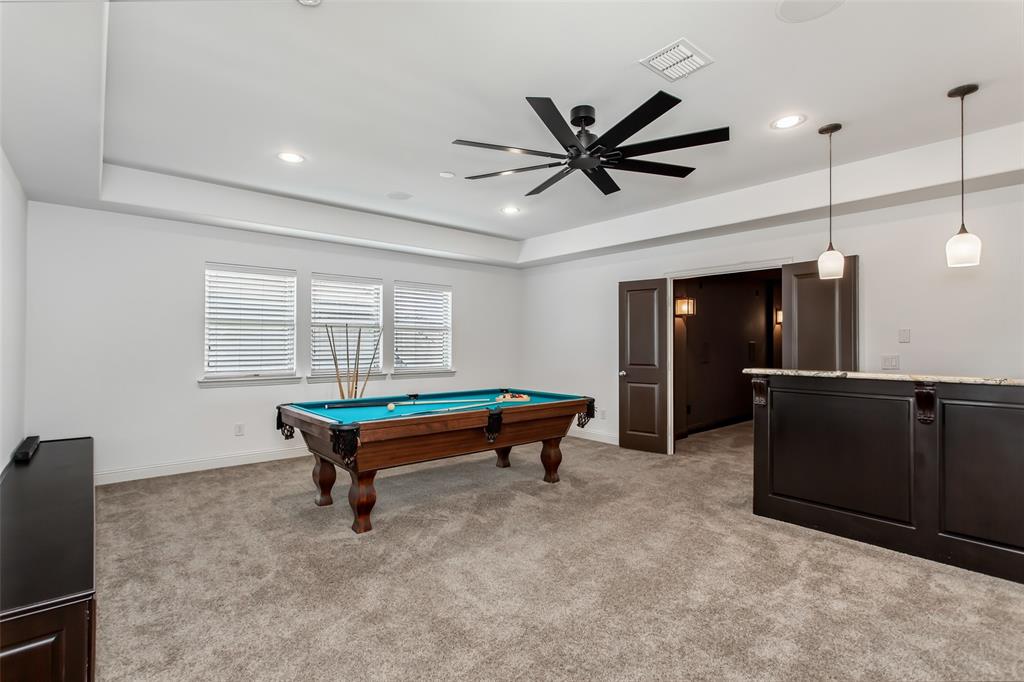 Recessed lighting, ceiling fan, tray ceiling, triple windows, and a built-in bar with pendant lighting