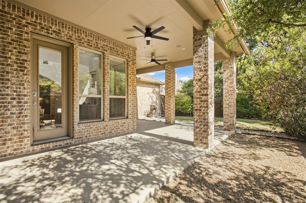Covered patio with brick columns, concrete flooring, and multiple ceiling fans