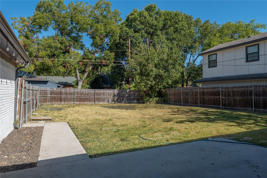 Expansive backyard featuring a concrete patio, a concrete walkway, and a full wood fence enclosure