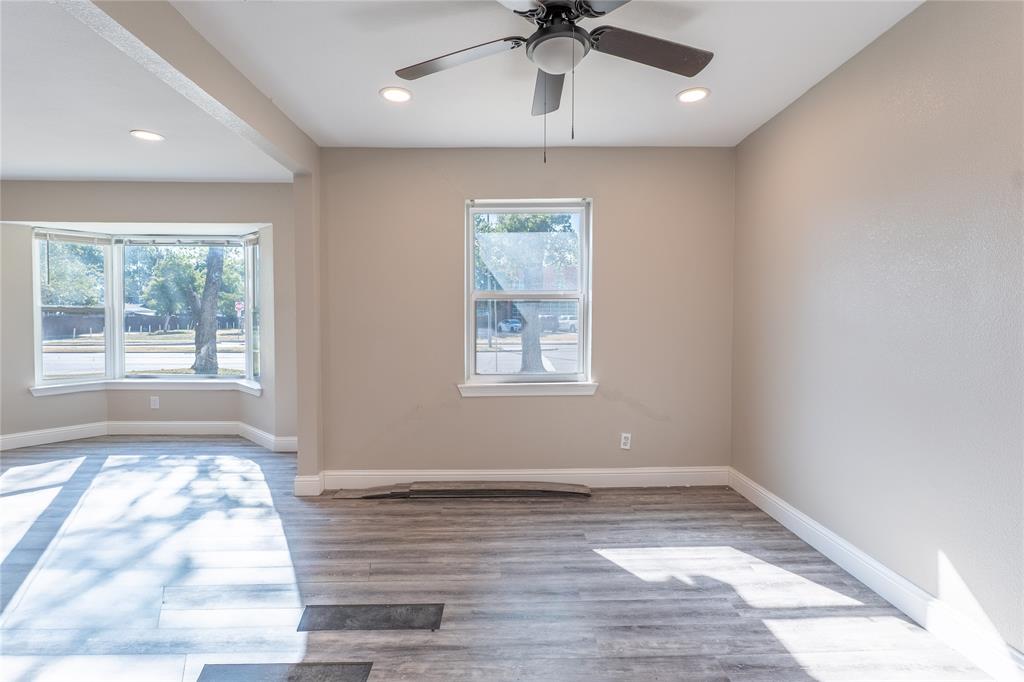 Wood-finish flooring, bay window, recessed lighting, ceiling fan, and neutral wall tones