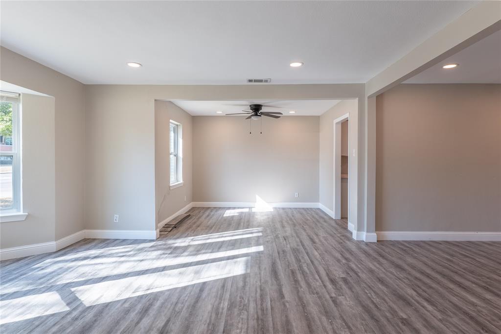 Spacious open-concept living area featuring wood-finish flooring, recessed lighting, and a ceiling fan