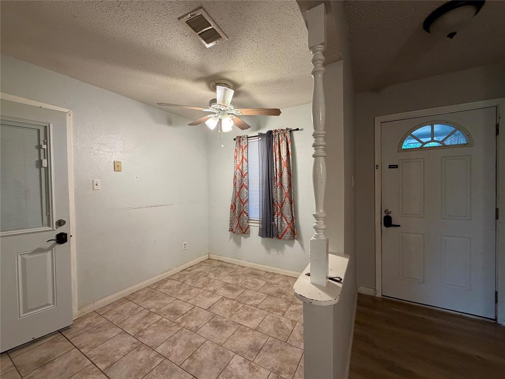 Tile flooring and wood-finish flooring, half-lite door, decorative interior column, ceiling fan with light fixture