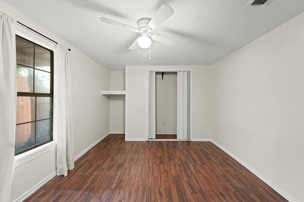 Wood-finish flooring, ceiling fan with integrated lighting, built-in shelving, and bifold closet doors