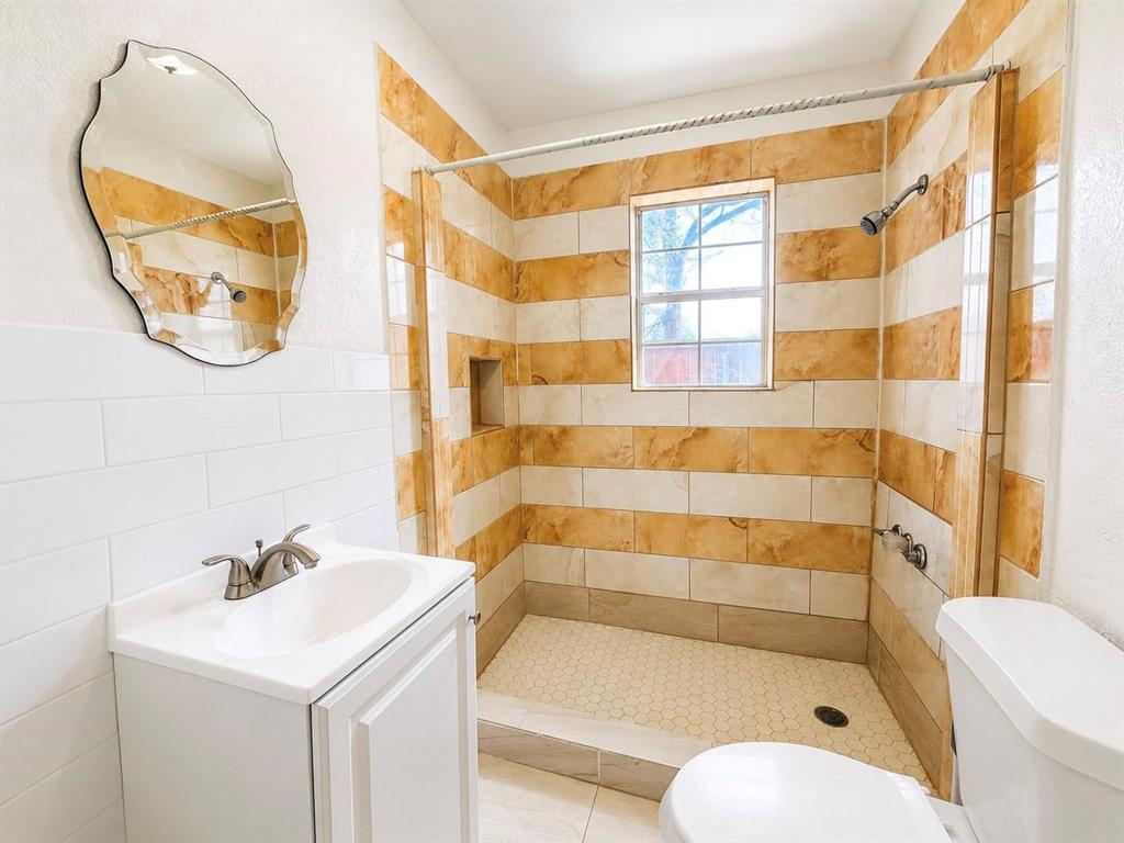 Walk-in shower with horizontal striped tiling and recessed niche