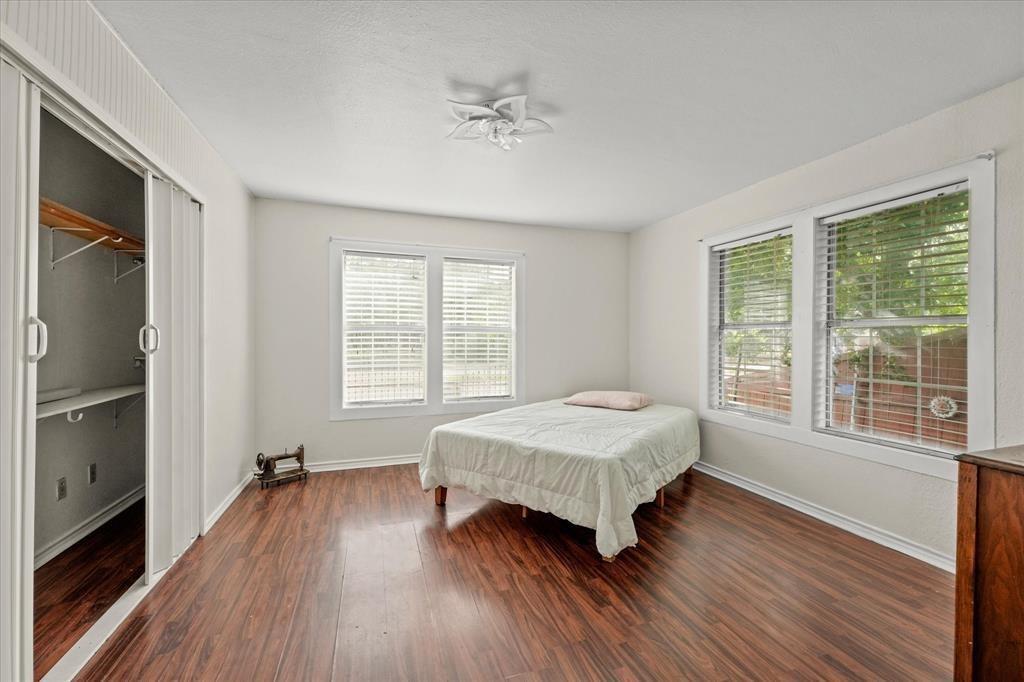 Wood-finish flooring, white walls, and multiple windows with blinds