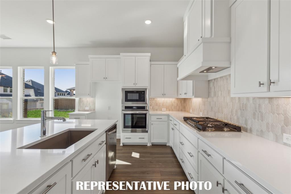 Beautiful cabinetry, gorgeous countertops and designer backsplash effortlessly pair with contemporary stainless steel to create a kitchen for the ages!  REPRESENTATIVE PHOTO