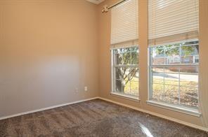 Unfurnished room featuring baseboards and dark carpet