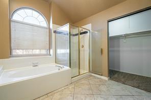 Bathroom featuring a bath, a shower stall, and tile patterned flooring