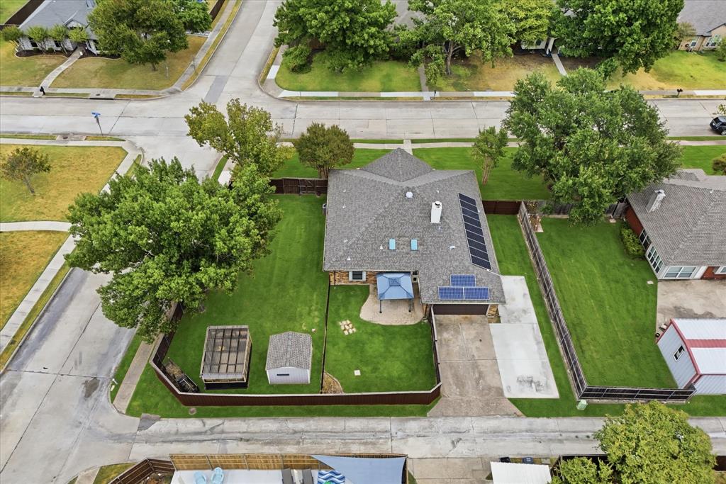 Aerial view showcases the home's single-story design, expansive corner lot, and mature trees.