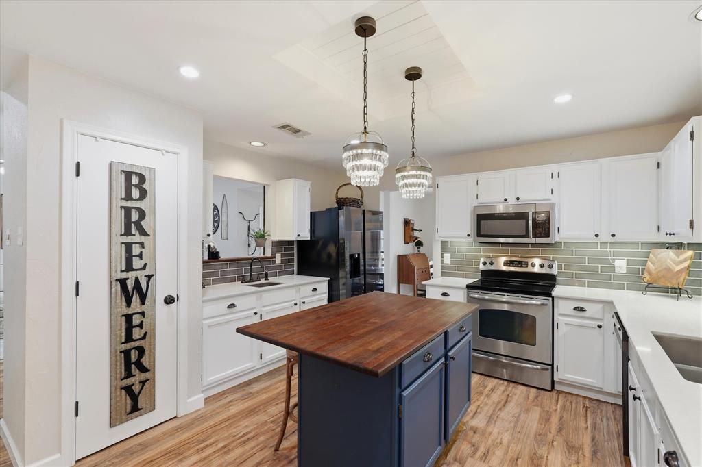 Thoughtfully updated kitchen offers an abundance of cabinetry, quartz countertops, tile backsplash and an easy connection to the dining area.