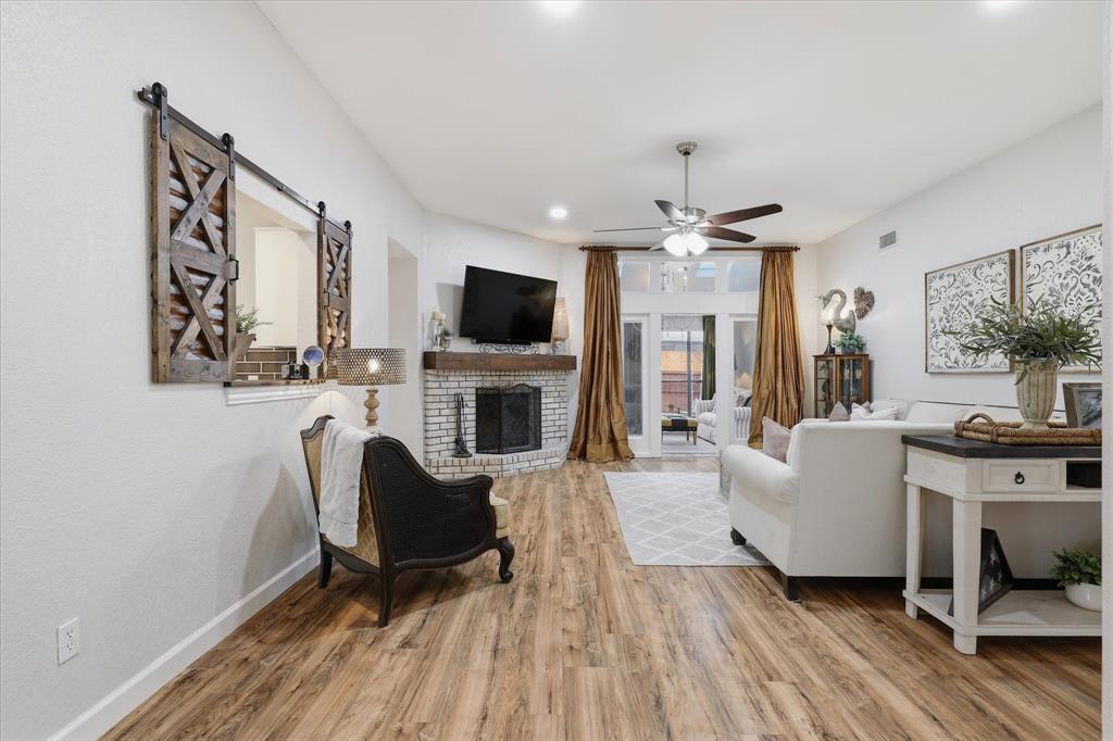 Spacious family room features wood-like flooring, a brick fireplace and an easy flow into the light-filled flex space.