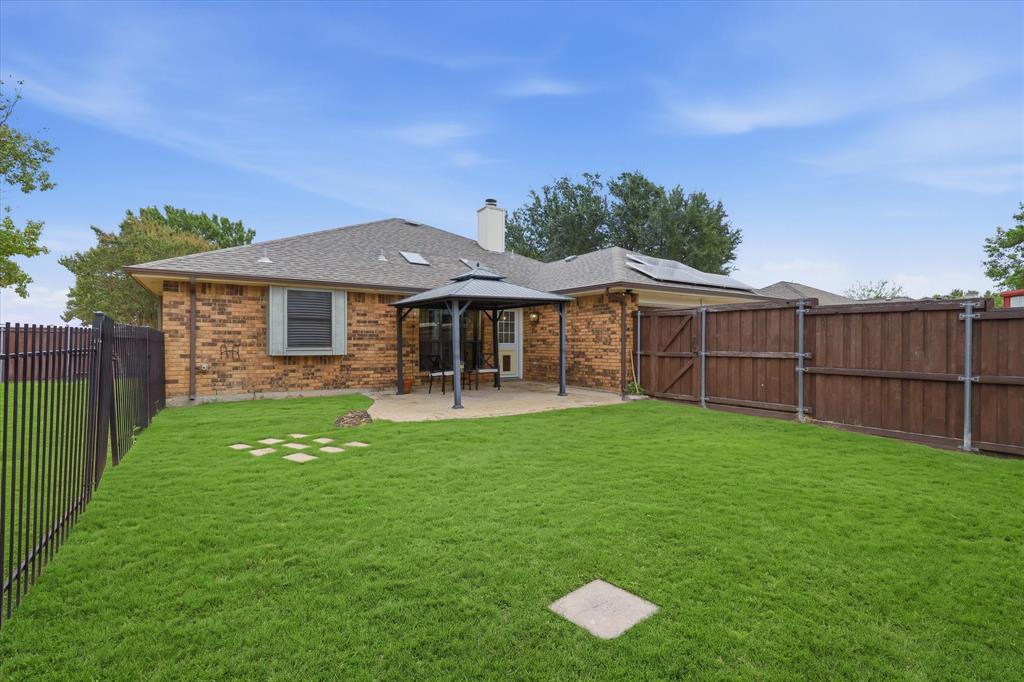 Spacious fenced backyard provides plenty of room for play, pets and outdoor entertaining, with a covered patio just off the home.