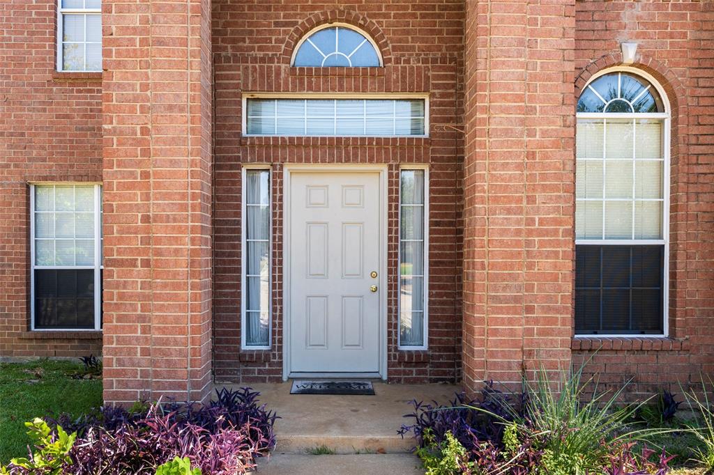 Red brick exterior featuring a white paneled entry door with sidelights