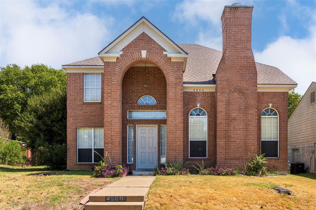 Brick exterior with arched entryway, brick chimney, gabled roofline, and arched window details