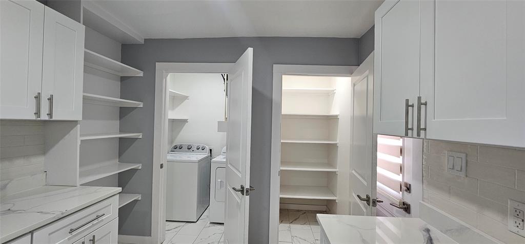 White shaker cabinetry, stone-finish countertops, subway tile backsplash, built-in shelving, and white appliances